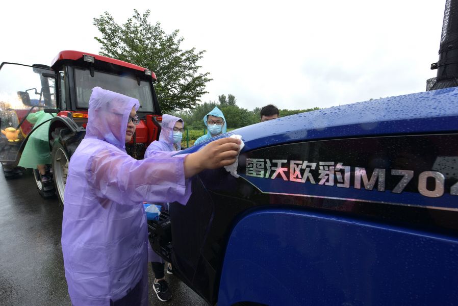 黄金城官方网站毕业生擦拭拖拉机（刘涛 摄）